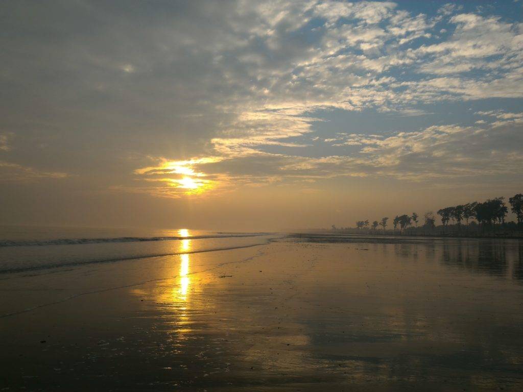 Orange sunrays on the sea during Sunset at Tajpur