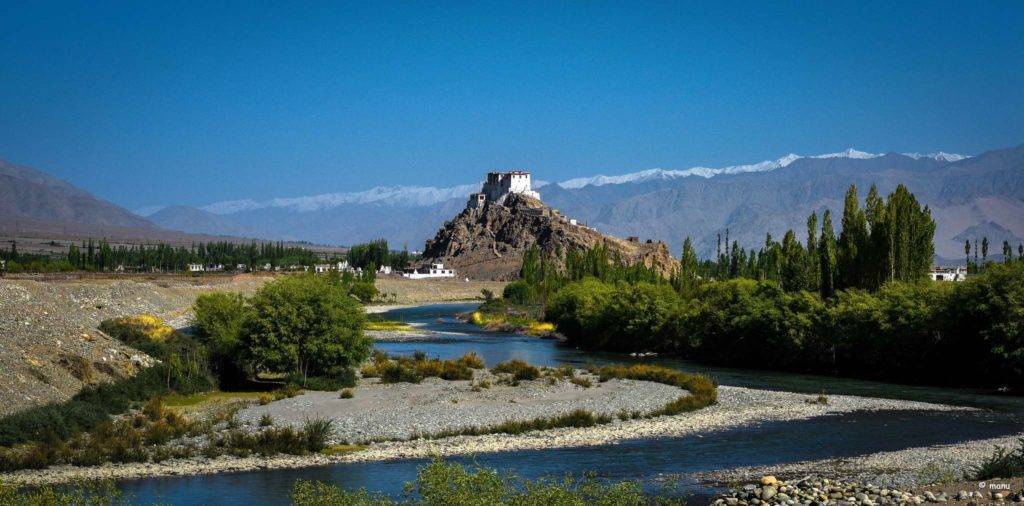 A river flowing past the Stakna Monastery situated on a hilltop