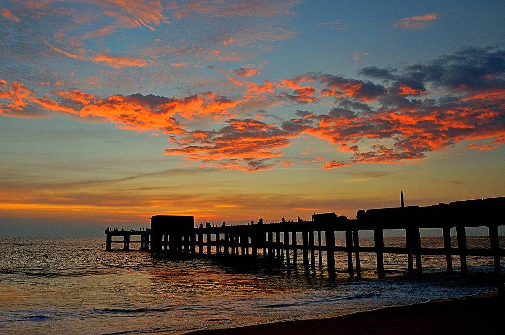 Orange colored clouds floating in the blue sky during Sunset at Valiyathura Pier