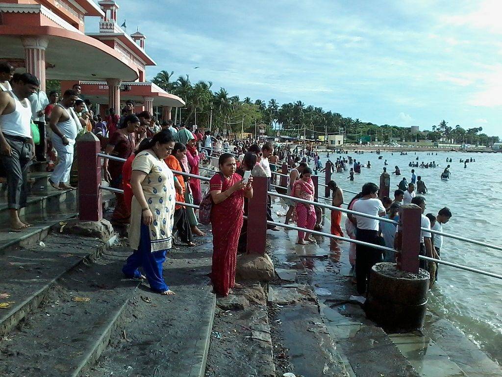 people taking a holy dip at the bathing ghat of Agni Theertham at Rameswaram