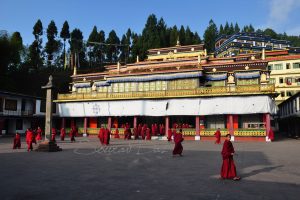 Monks walking in front of the colorful building of Rumtek Monastry at Gangtok