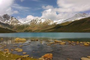 Clear waters of Gangabal Lake surrounded by snow capped mountains