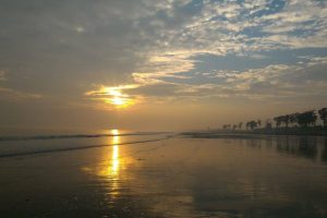 Orange sunrays on the sea during Sunset at Tajpur